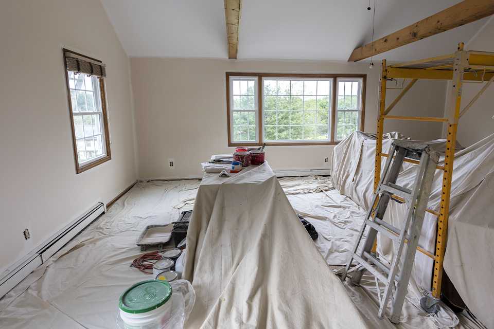 Bedroom furniture covered in dust sheets.