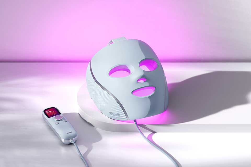 LED face mask lit up on table