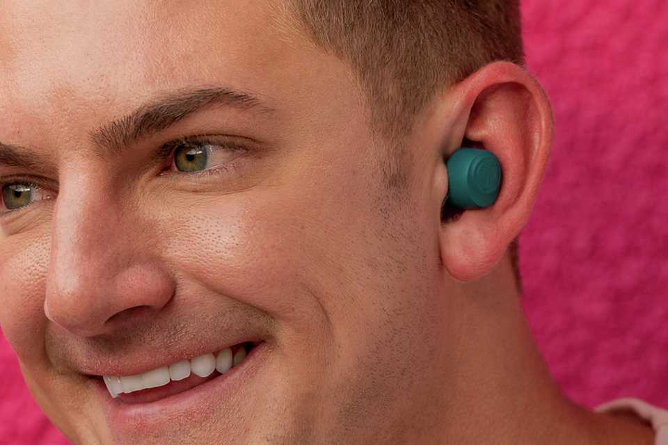 A man using teal JLab GO Air Pop In-Ear True Wireless Earbuds.