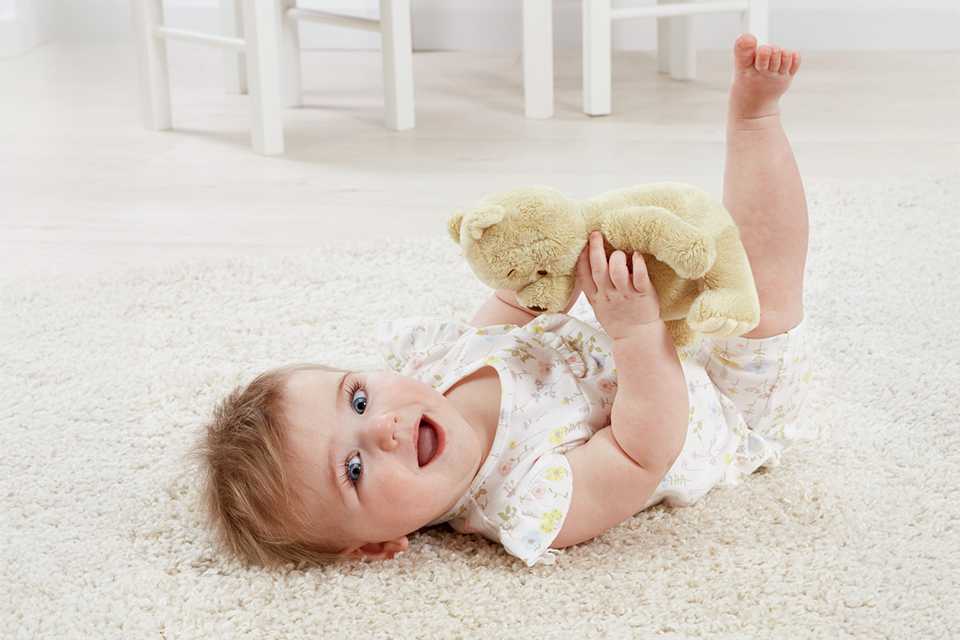 A baby with a Disney Classic Winnie the Pooh Soft Plush Toy.