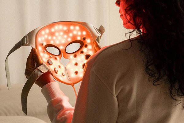 Woman holding LED face mask for skincare