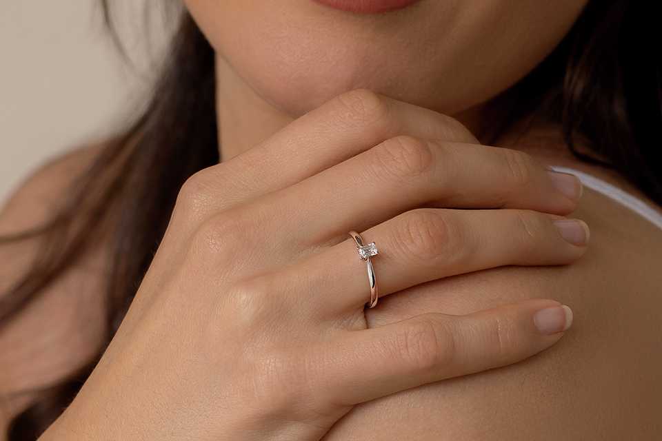 A woman wearing a princess cut ring.