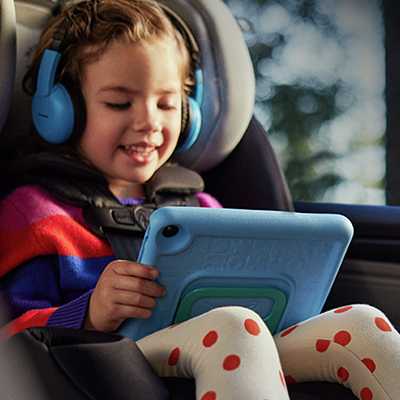 A child using a red Amazon Fire 7 Kids Tablet for ages 3-7, 7in 16GB.