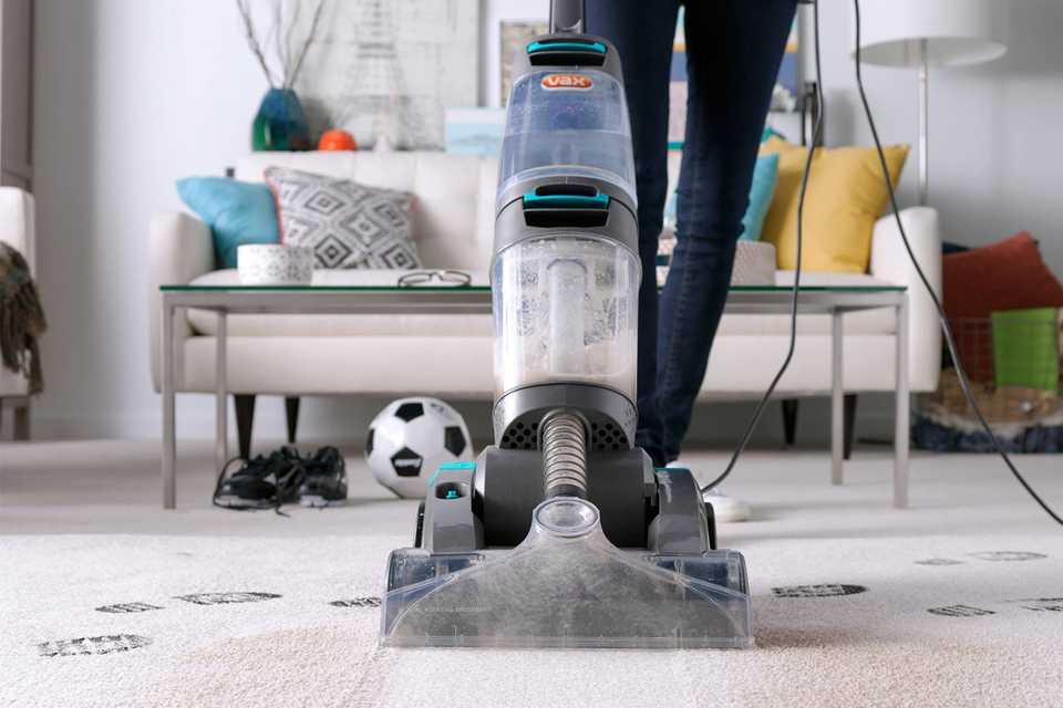A woman cleaning the carpet with a Vax Dual Power Pet Advance Upright Carpet Cleaner.