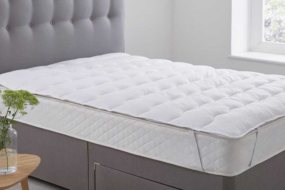 Mattress topper on matress in bedroom.
