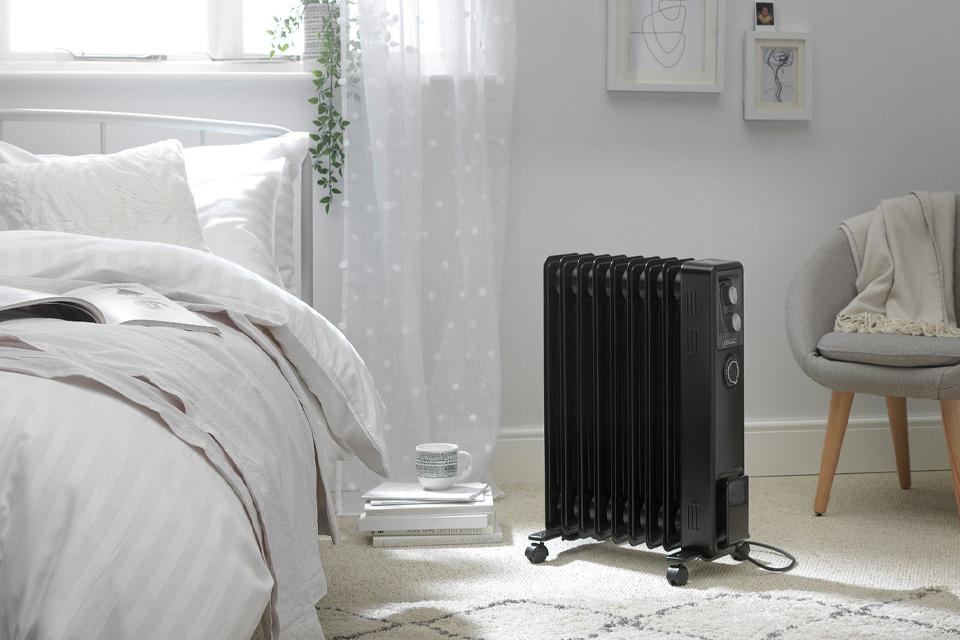 Portable radiator next to bed in bedroom.
