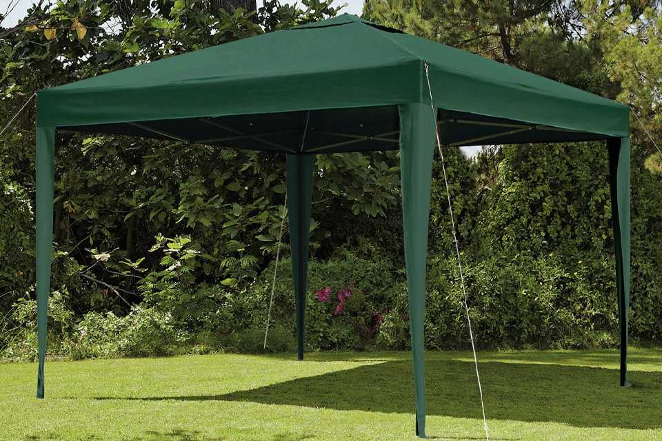 A green pop-up gazebo on a campsite.