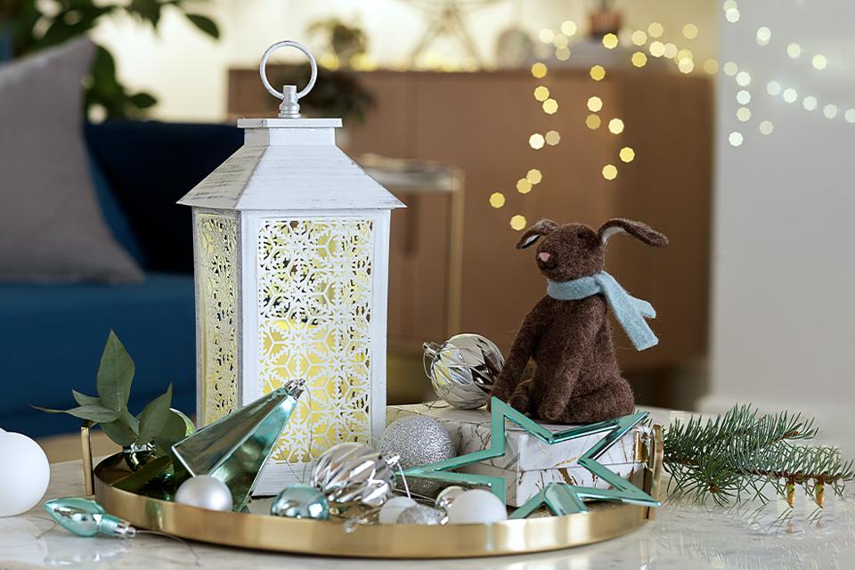 A tray decorated with a white lantern and felt hare table decoration.