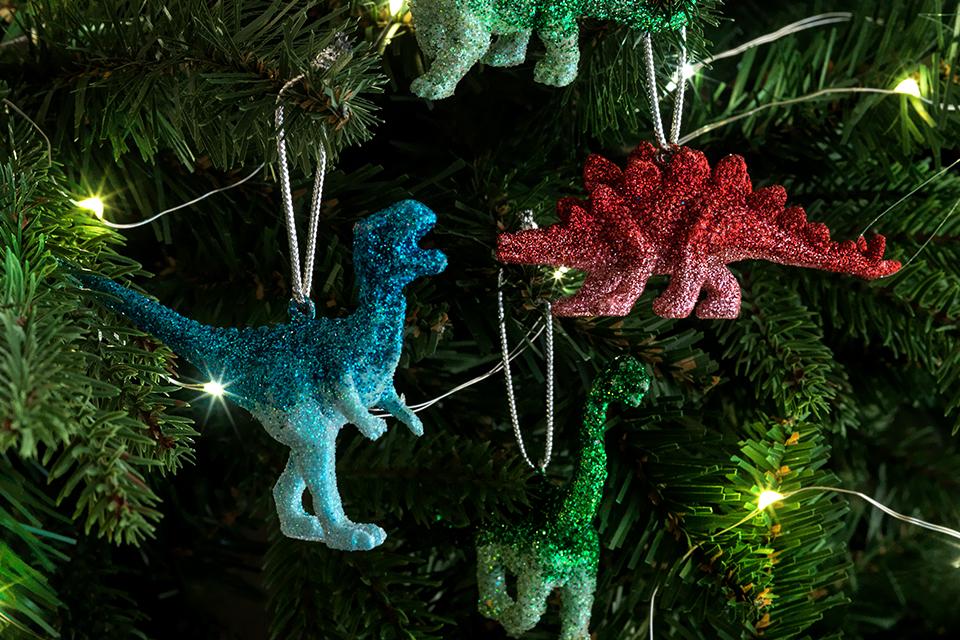 Colourful dinosaur baubles on a green Christmas tree.