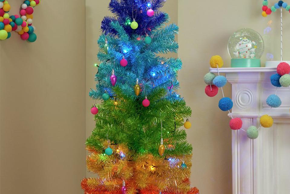 A lit rainbow Christmas tree surrounded by gifts.