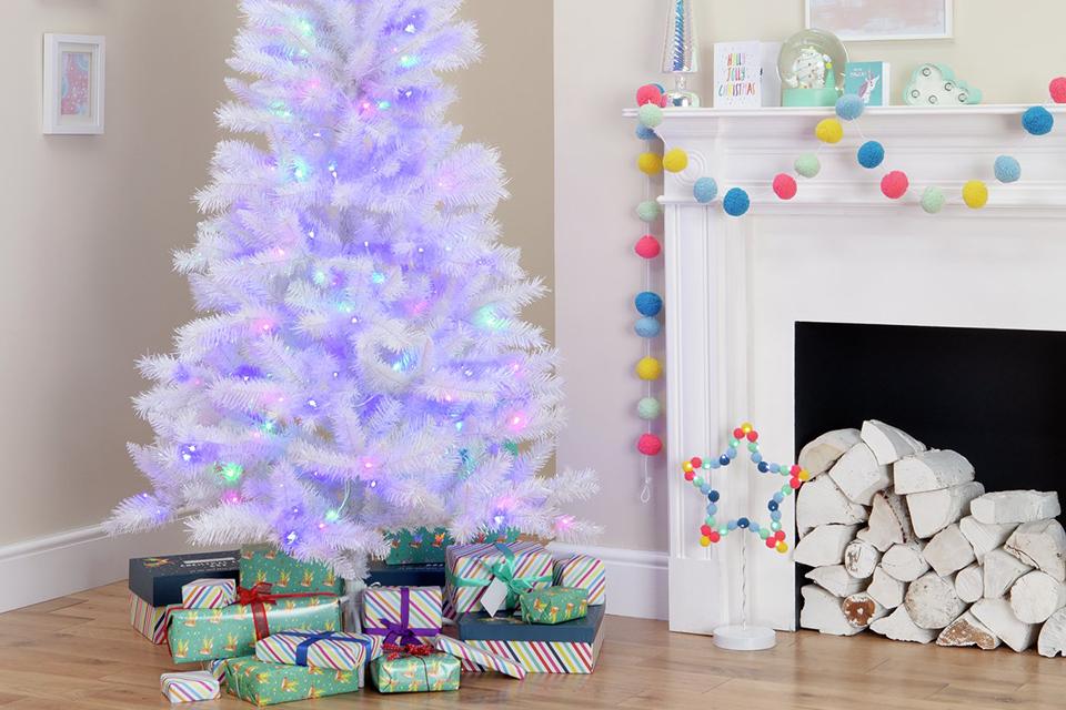Neatly wrapped gift boxes placed in front of a Christmas tree.