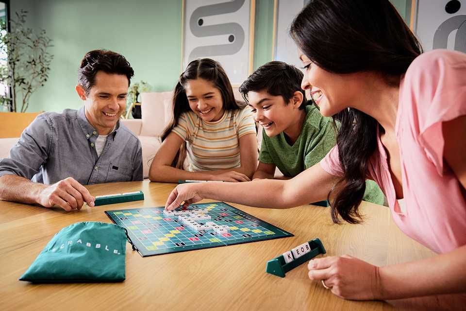 A family playing Scrabble original board game.