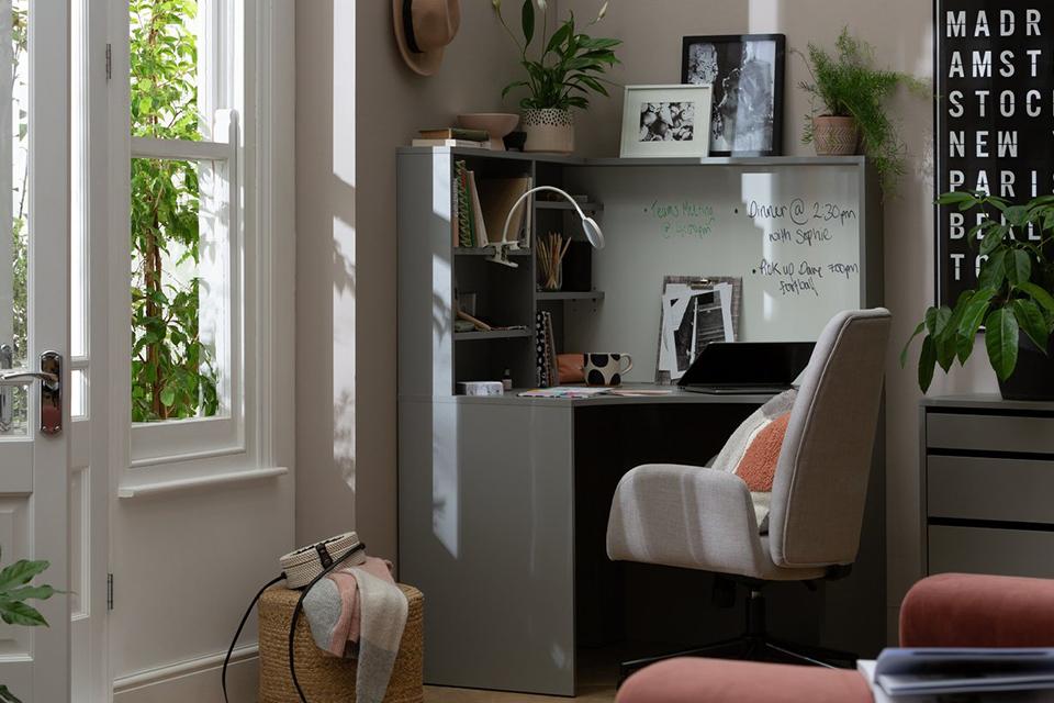 An image of a small, corner desk in an office environment.