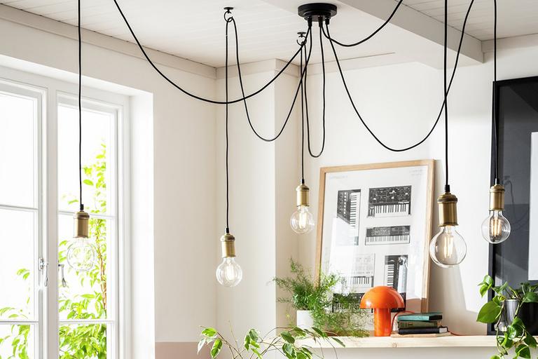 Industrial style ceiling light with metallic detailing and exposed filament bulbs.