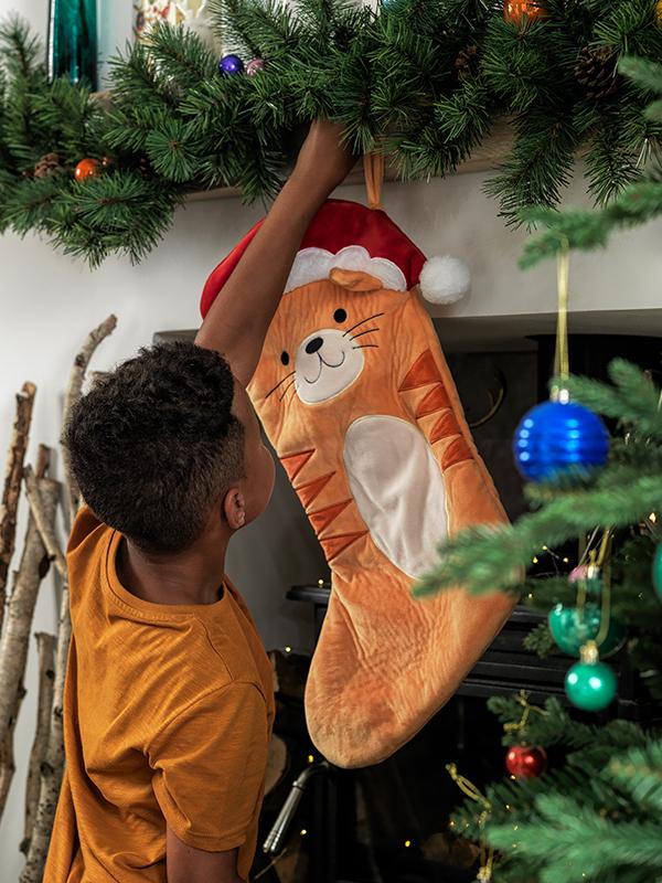 A boy hangs up his cat stocking.