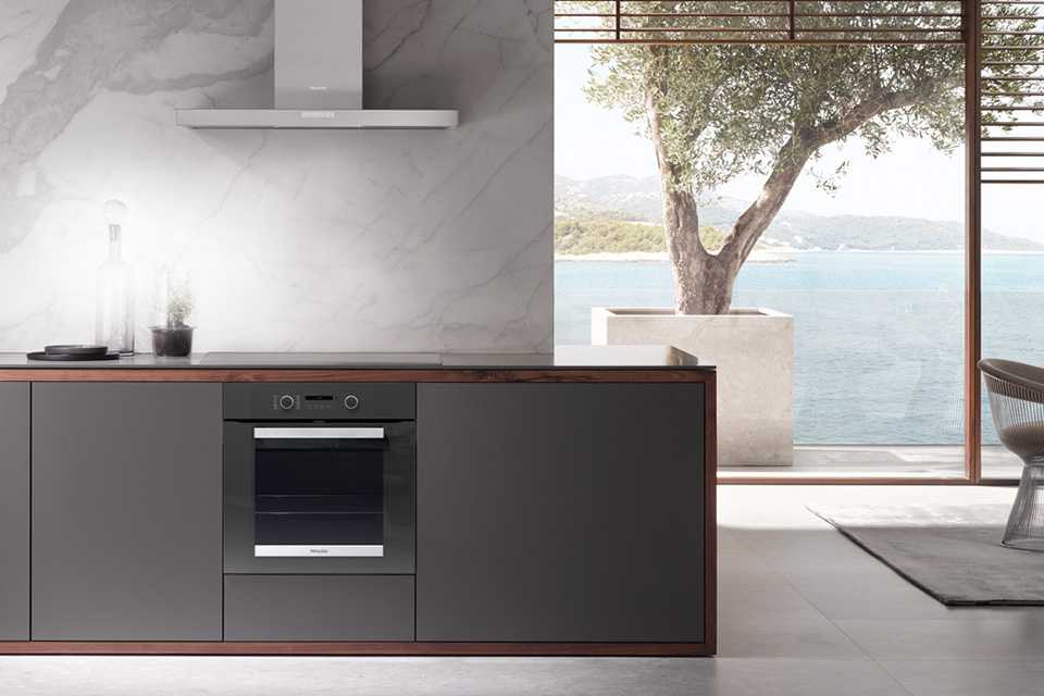 A grey-toned, scenic kitchen with a grey Miele built-in oven.