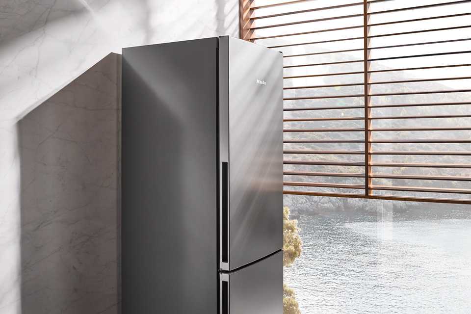 Angled view of a dark grey Miele refrigerator in a ktichen.