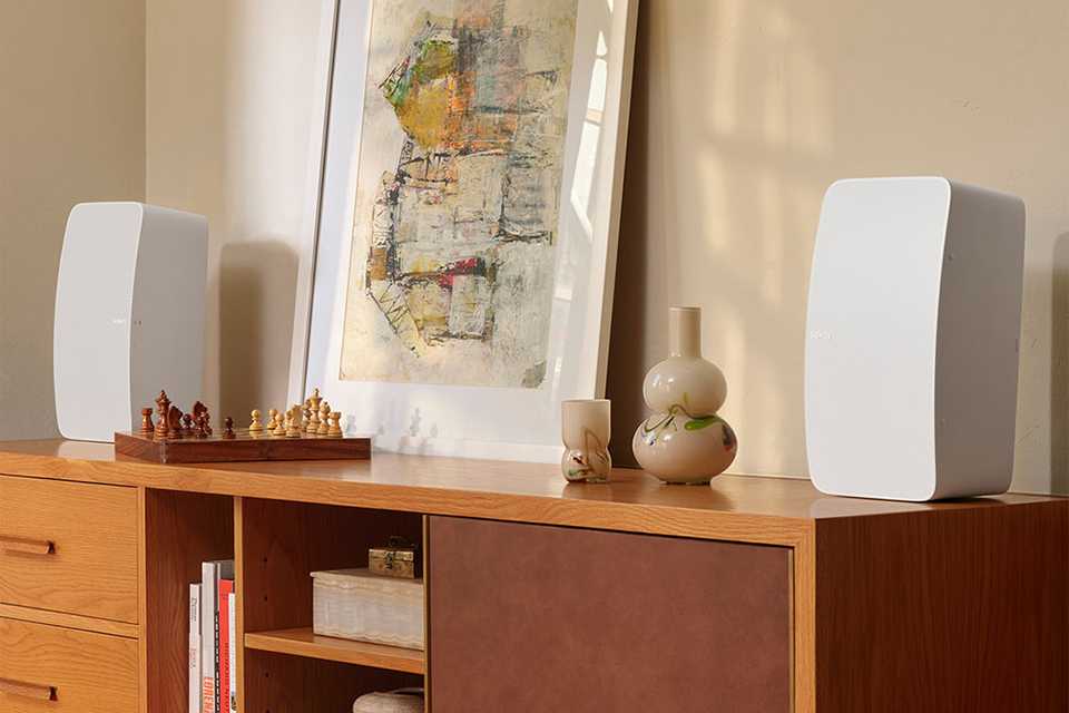 Two white Sonos subwoofers placed on a table.