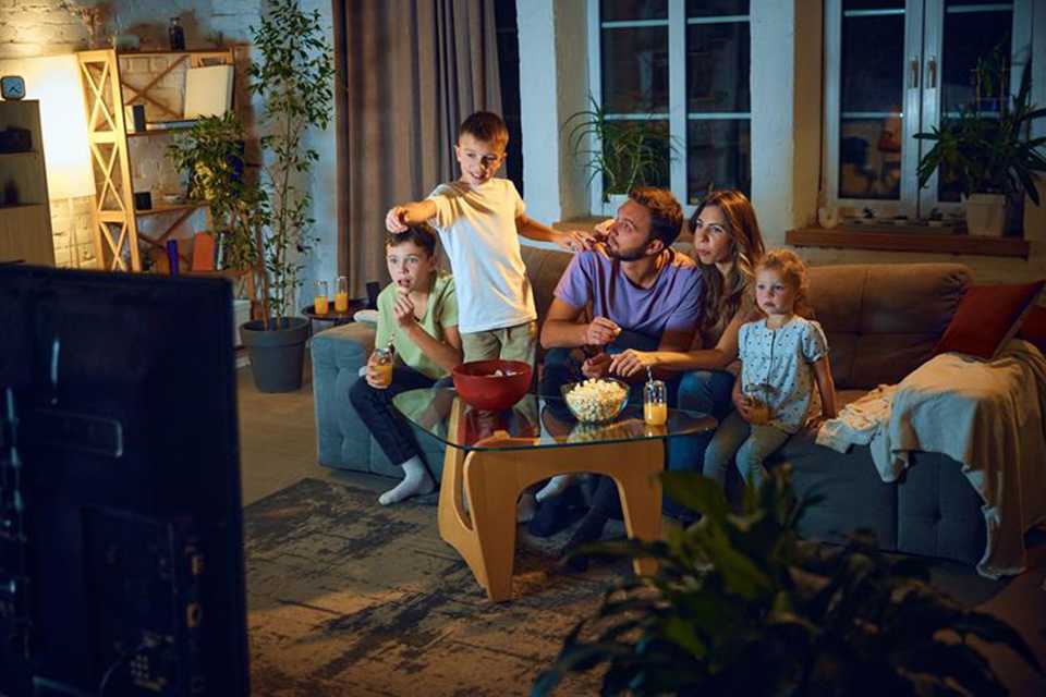 A family of five watching Harry Potter movie on their TV.