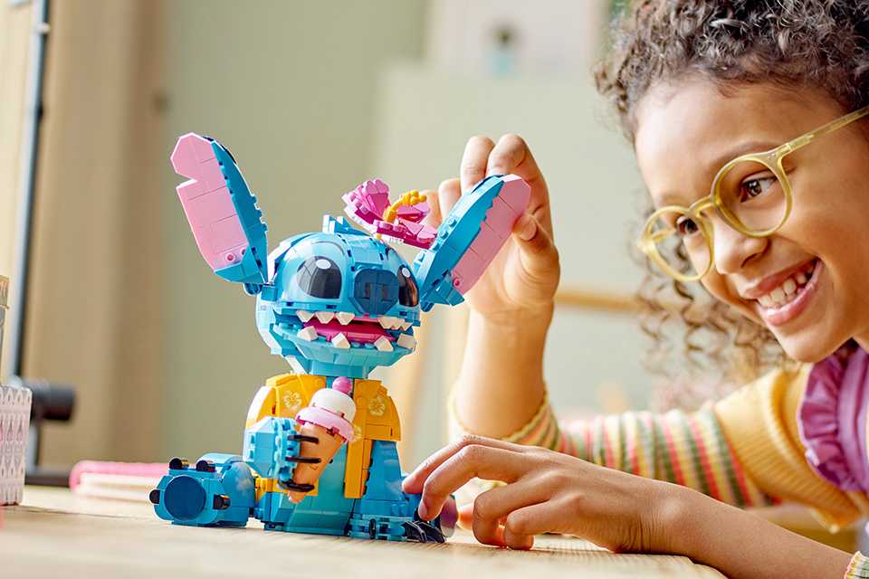 Girl playing with LEGO® Stitch set.