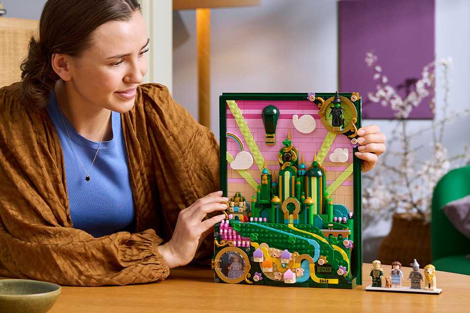 Woman looking at the LEGO® Wicked Emerald City Wall Art set.