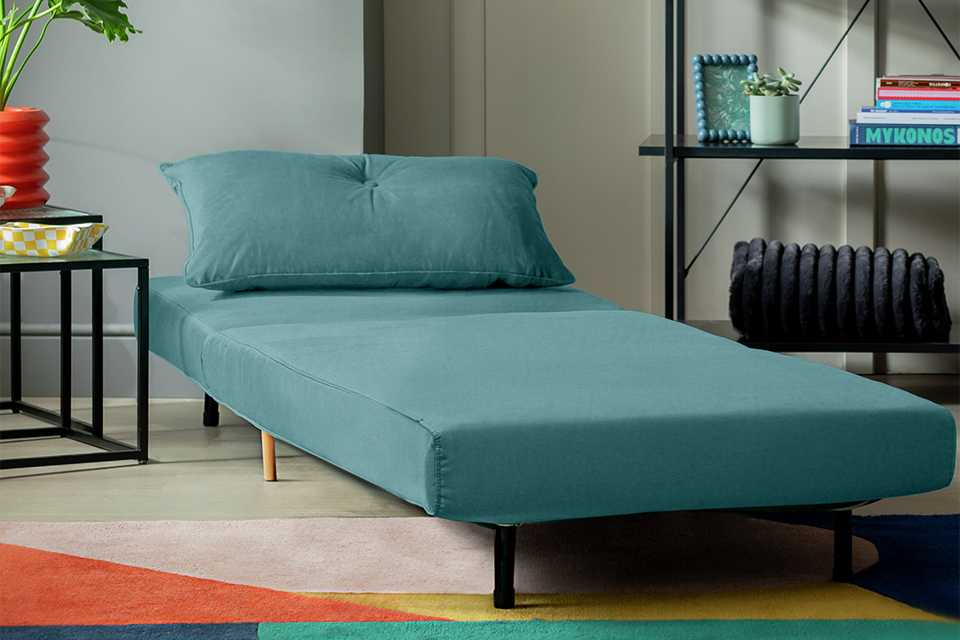 A Habitat velvet single chair bed in a living room.