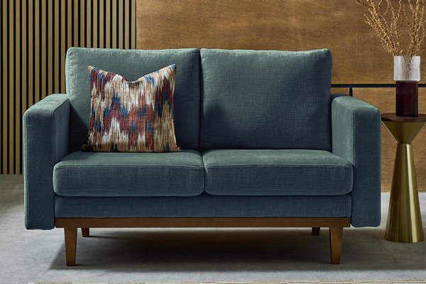 A blue Habitat two-seater sofa with a cushion in a living room.