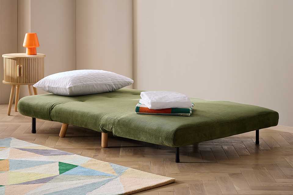 A Habitat fabric 2-seater small double sofa bed in green.