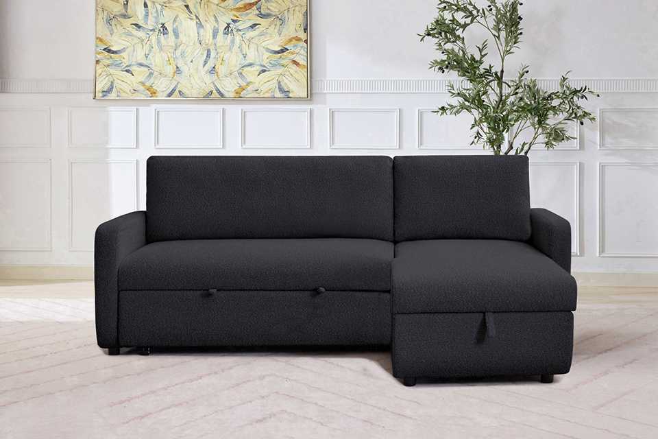 A Habitat bouclé fabric corner chaise sofa bed in green.