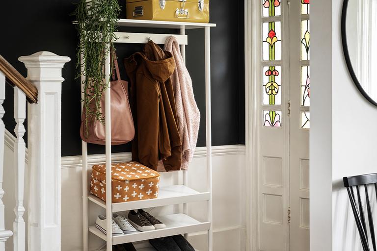 White coat rack with shoe storage.