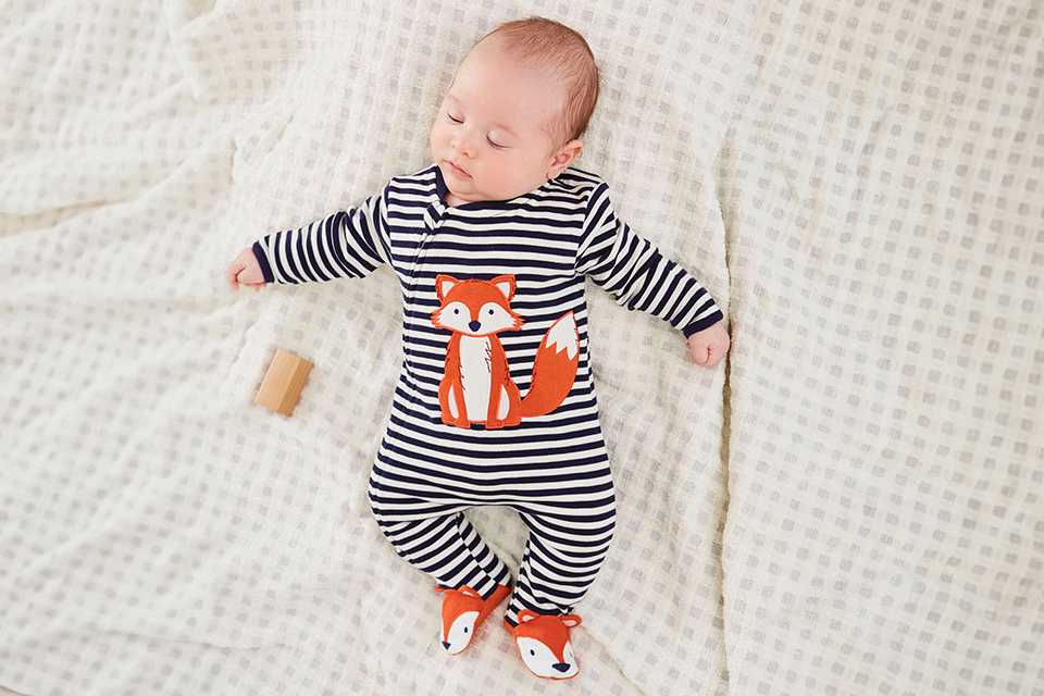 A newborn sleeping in a JOJO MAMAN BÉBÉ Fox Applique zip sleepsuit.