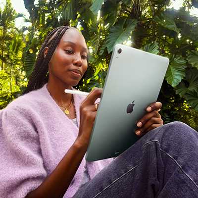 A woman using an Apple iPad Air 2025 13 Inch Wi-Fi 256GB - Space Grey on a holiday.