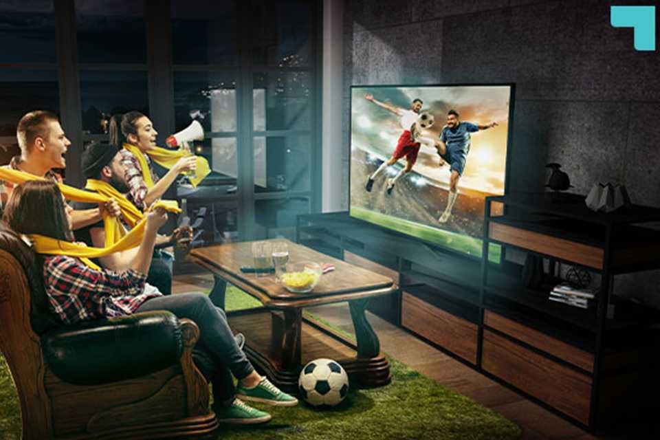 People watching a football match on TV and cheering together.