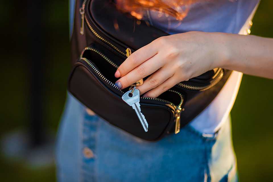 Person putting keys in bum bag.