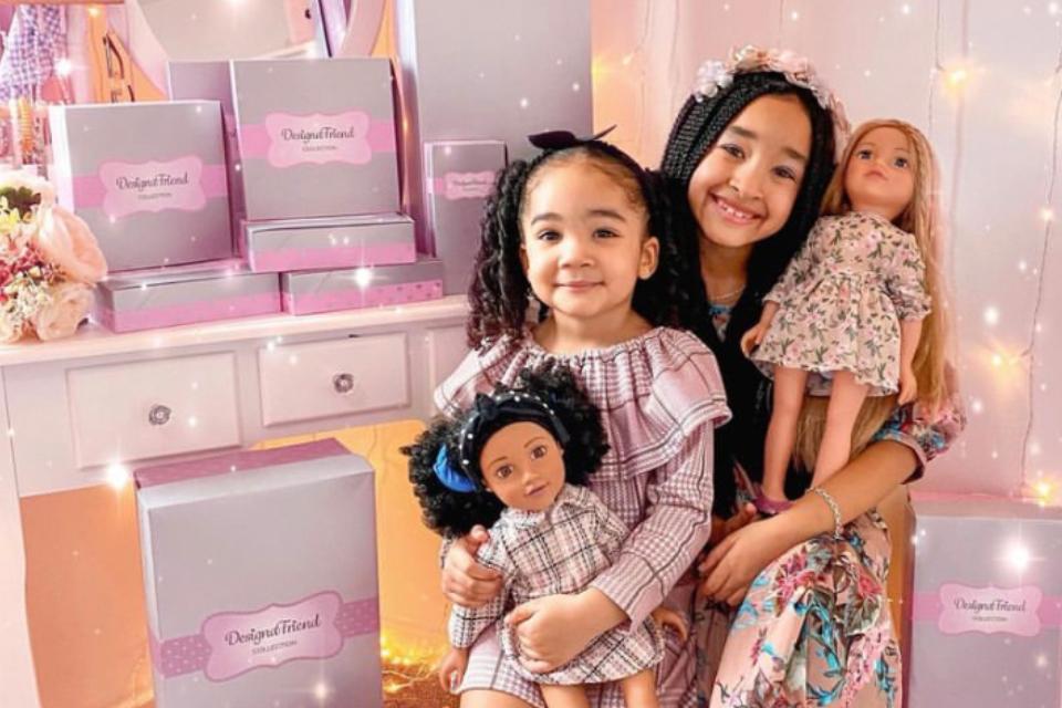 Two little girls, each with a DesignaFriend doll.