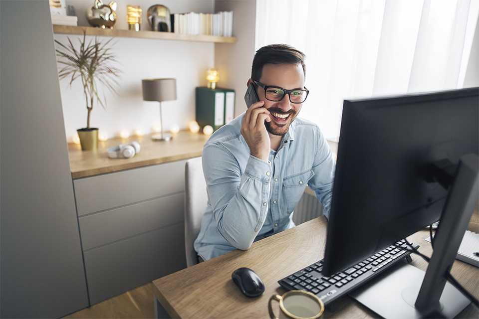 Image of a man at a desk on the phone.