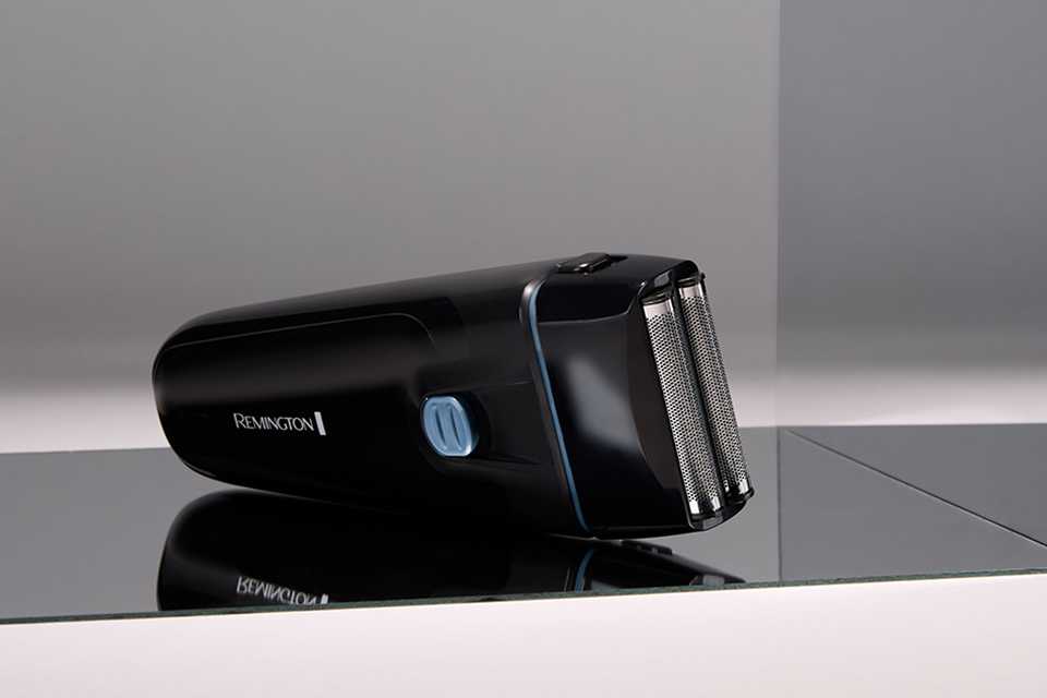 A black Remington foil shaver placed on a black counter.