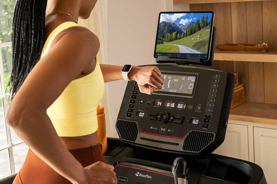 A woman using BowFlex BFX T9 Folding Treadmill with Incline and Bluetooth.