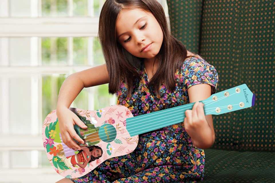 A girl playing a Disney Moana My 1st Guitar.