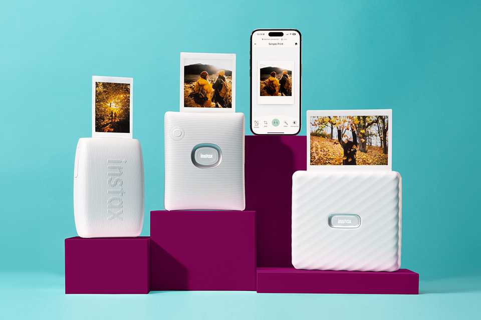 Various white instax™ smartphone photo printers placed on a burgundy podium.