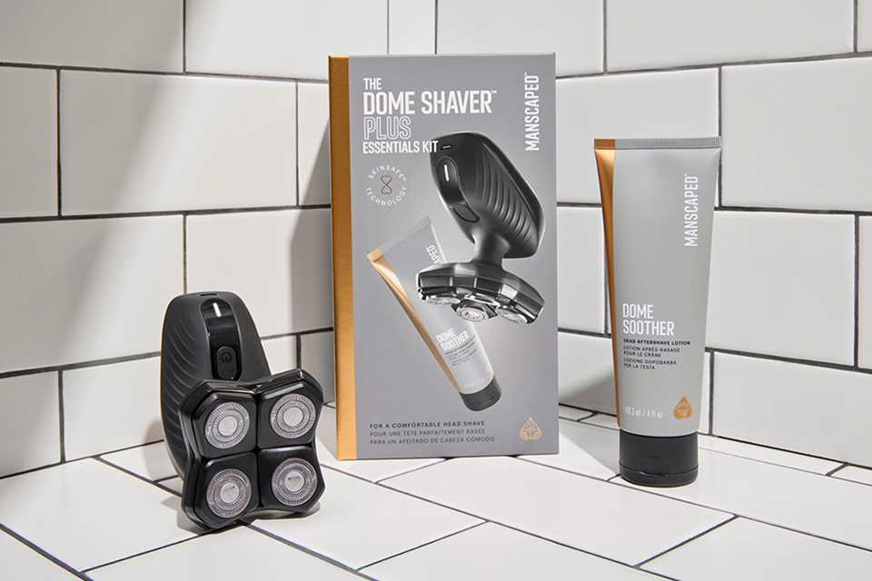 Shot of the products from Manscaped Dome Shaver Plus Essentials kit laid out on white tiles.