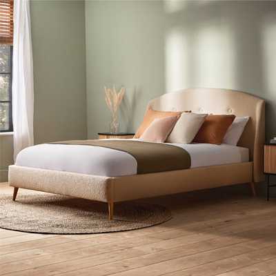 Green bedroom with cream boucle bed in bedroom.