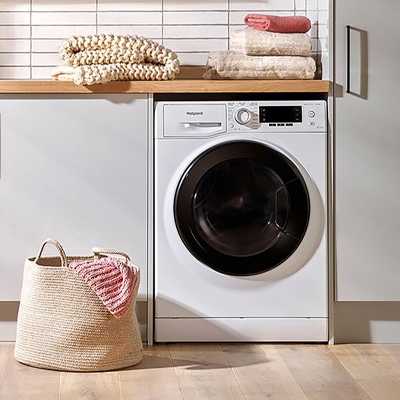 Hotpoint NDD86448WDAUK 8kg/6kg 1400 Spin Washer Dryer in white colour in a laundry room.