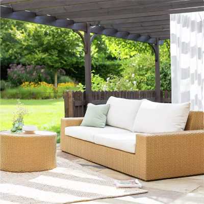 Garden chairs with white cushions in garden.