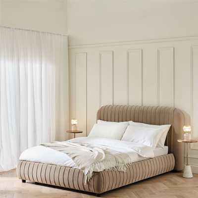 Cloud cream lined bedframe with white bedding in large room painted white.