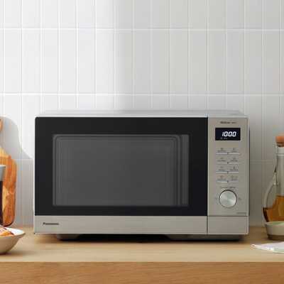 Panasonic 1000W Standard Microwave NN-SD37QSBPQ in grey colour placed on a wooden counter.