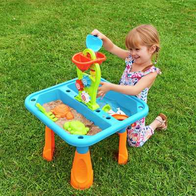 A child playing outdoors with Chad Valley Sand and Water Table.