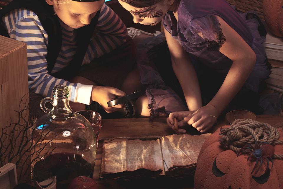 A boy inspects his Halloween loot in a pumpkin basket.