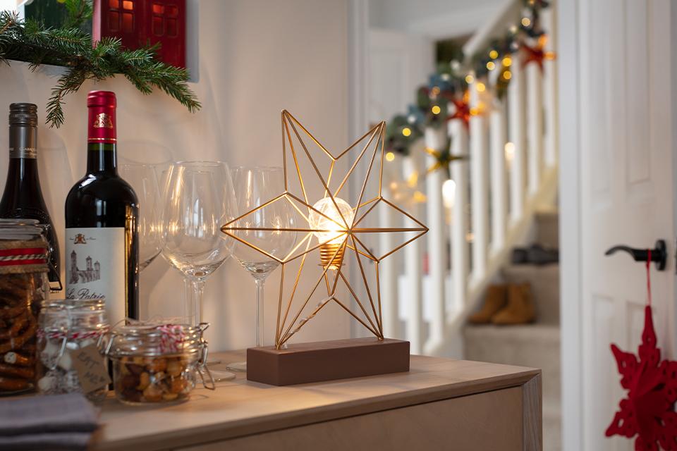 A gold star-shaped table lamp sat next to some Christmas treats and wine glasses.