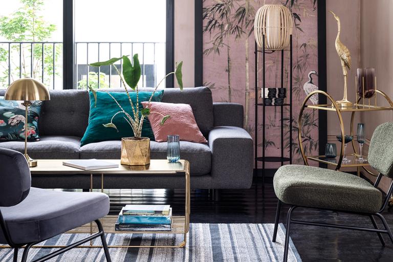 Living room setting with grey sofa and armchairs with pink and turqouise pillows.